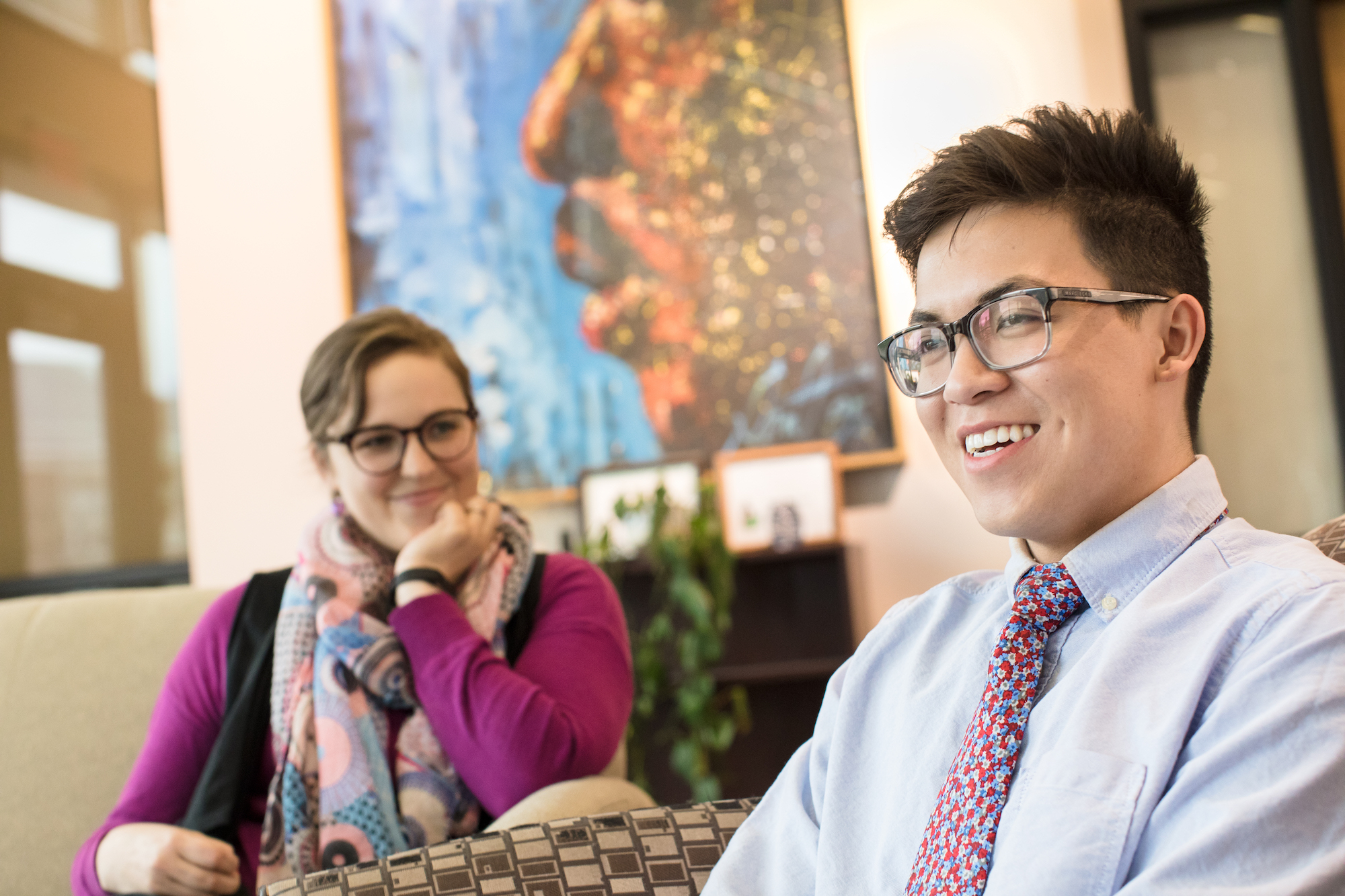 Student, right, wearing dress shirt, tie, and glasses