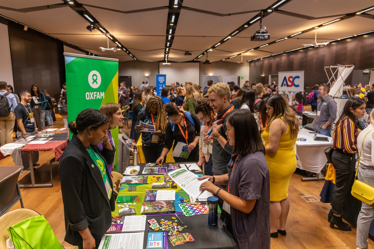 Conference Attendees talking to representatives from Oxfam at vendor table, IMPACT National Conference 2020